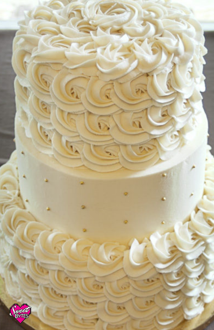 A close up of a 3 tiered cake with sweet bytes vanilla buttercream recipe