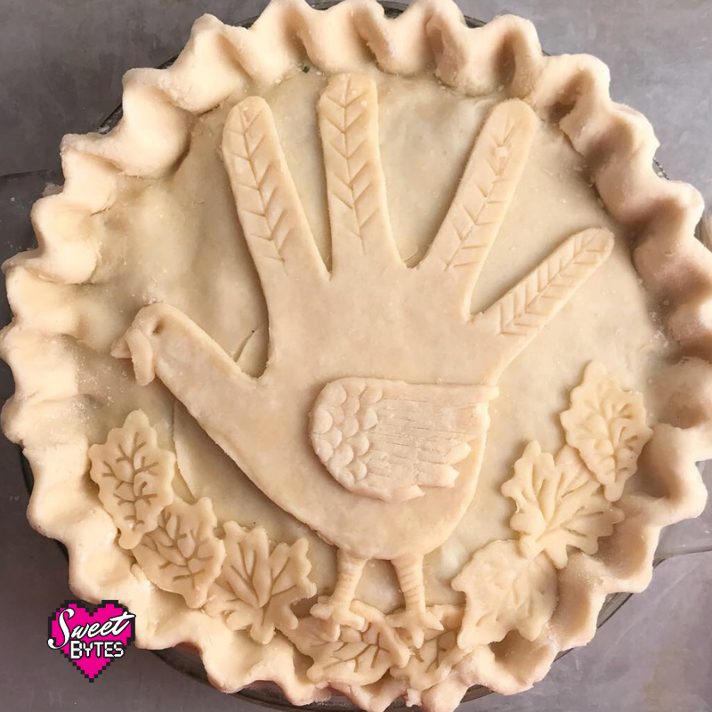 Raw turkey pot pie decorated with a hand turkey and fall leaves cut out of pie crust