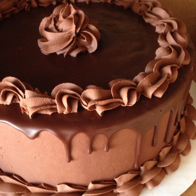 Close up view of a chocolate ganache covered cake