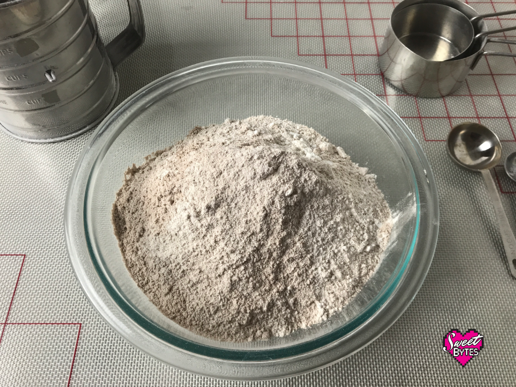 All of the dry ingredients for red velvet cake sifted in a clear glass bowl