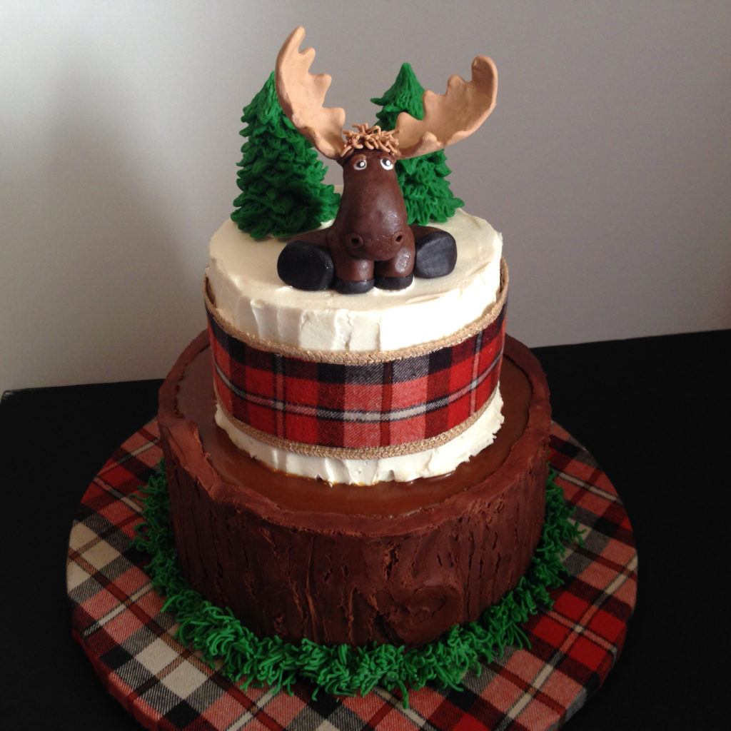 A moose on top of a tiered cake.