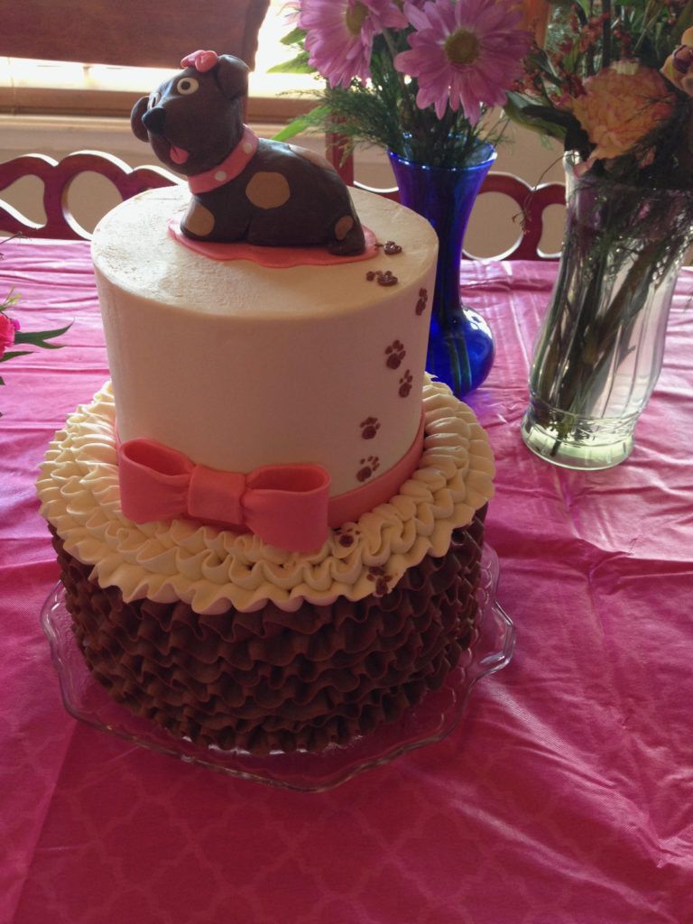 2 tier ruffle cake with modeling chocolate puppy on top