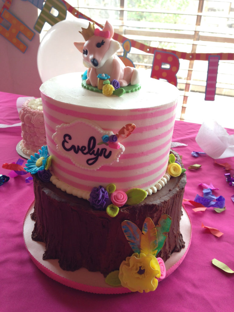 Woodland fox two tier cake with a tree stump bottom and pink and white striped buttercream top