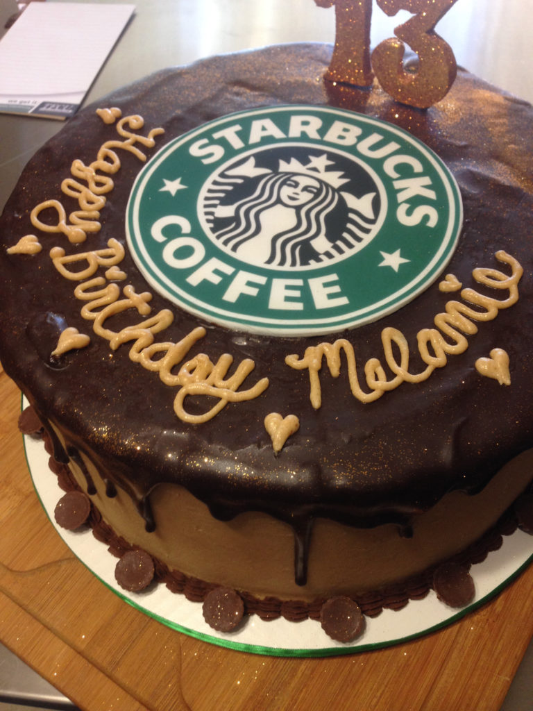 Top shot of a chocolate drip cake with edible image for the starbucks coffee logo